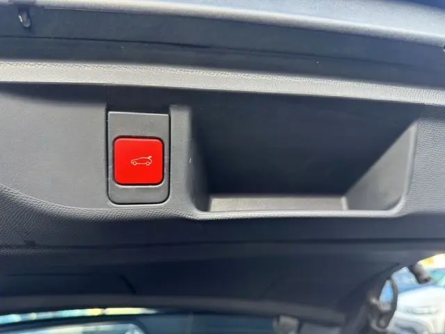 Bouton rouge d'ouverture électrique du hayon sur le coffre intérieur d'un DS4 noir 2022 vue rapprochée.