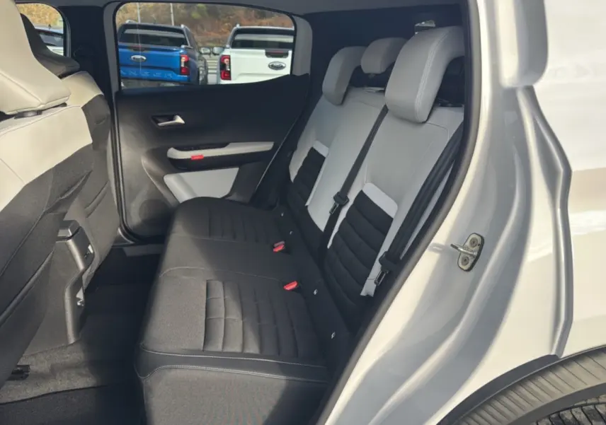 Vue côté droit de l'intérieur arrière du Citroën C3 Aircross blanc banquise, sièges tissu bicolores noirs et gris.