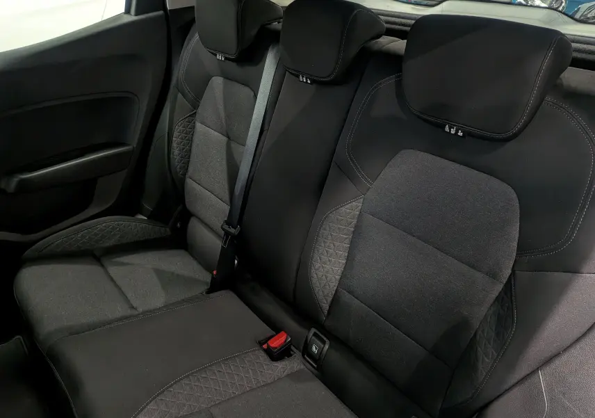 Vue intérieure des sièges arrière en tissu gris foncé de la Renault Clio V Business, avec ceinture de sécurité centrale visible.