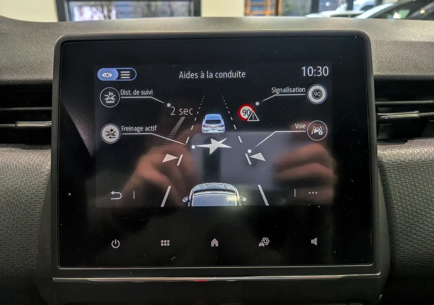 Écran tactile intérieur de la Renault Clio V blanc Glacier montrant les aides à la conduite et la signalisation à 10h30.