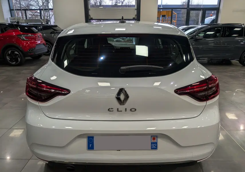 Vue arrière d'une Renault Clio V blanche Glacier, avec feux arrière LED et logo Renault bien visible.