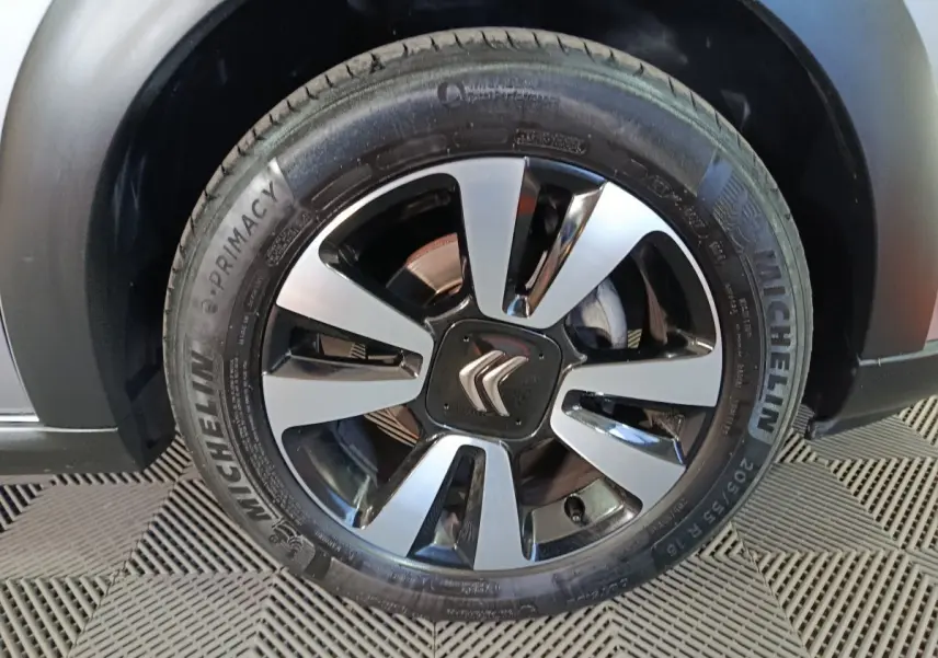 Gros plan sur la roue avant droite d’une Citroën C3 gris foncé avec jante alliage bicolore et pneu Michelin.