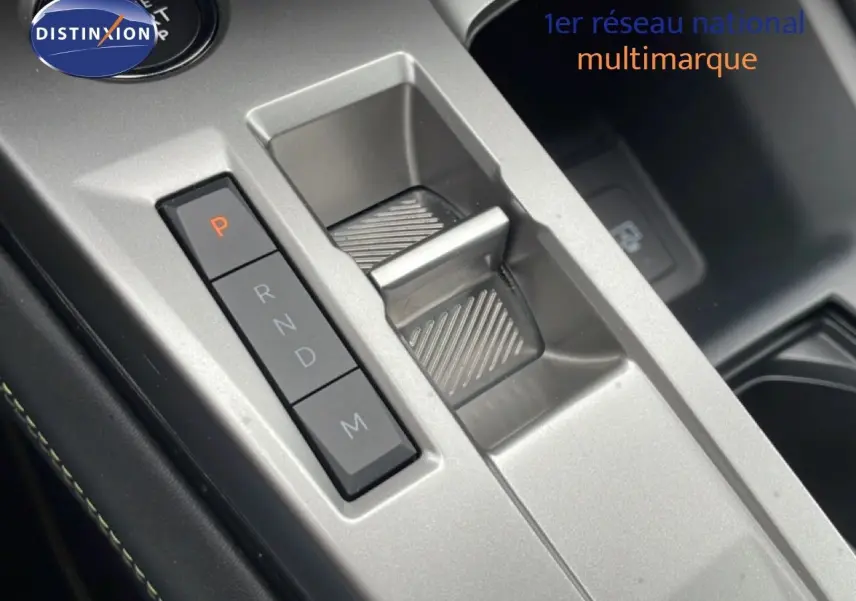 Gros plan sur la console centrale argentée avec sélecteur de boîte automatique et boutons de commande du Peugeot 408 Hybrid 2024 noir métal.