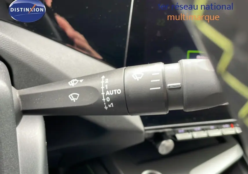 Gros plan sur la commande d’essuie-glace à gauche du volant dans l’habitacle d’une Peugeot 408 noire.