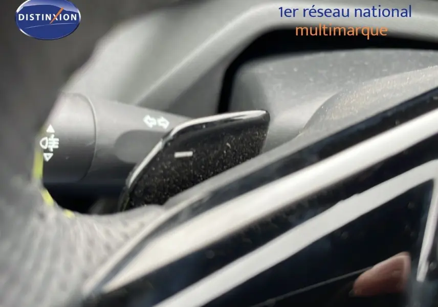 Gros plan sur la commande de clignotant et palette de frein moteur dans l’habitacle d’une Peugeot 408 noir métal 2024.