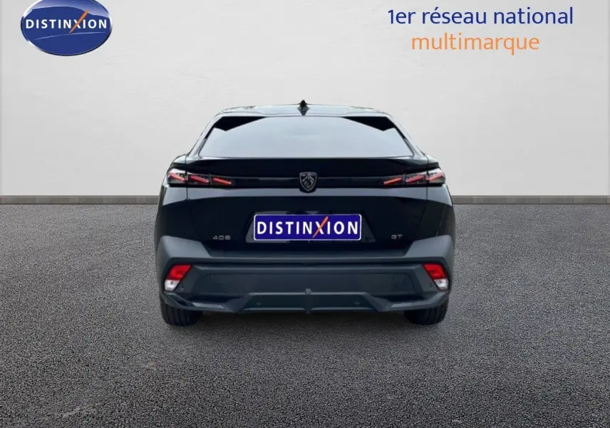 Vue arrière d'une Peugeot 408 Hybrid 145ch GT noire métal, mettant en valeur ses feux arrière fins et son design moderne.