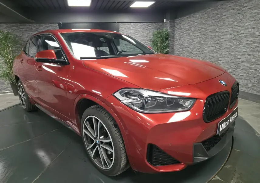 BMW X2 sDrive 18d M Sport orange métallisé vue 3/4 avant droit avec jantes alliage 19 pouces et calandre noire.