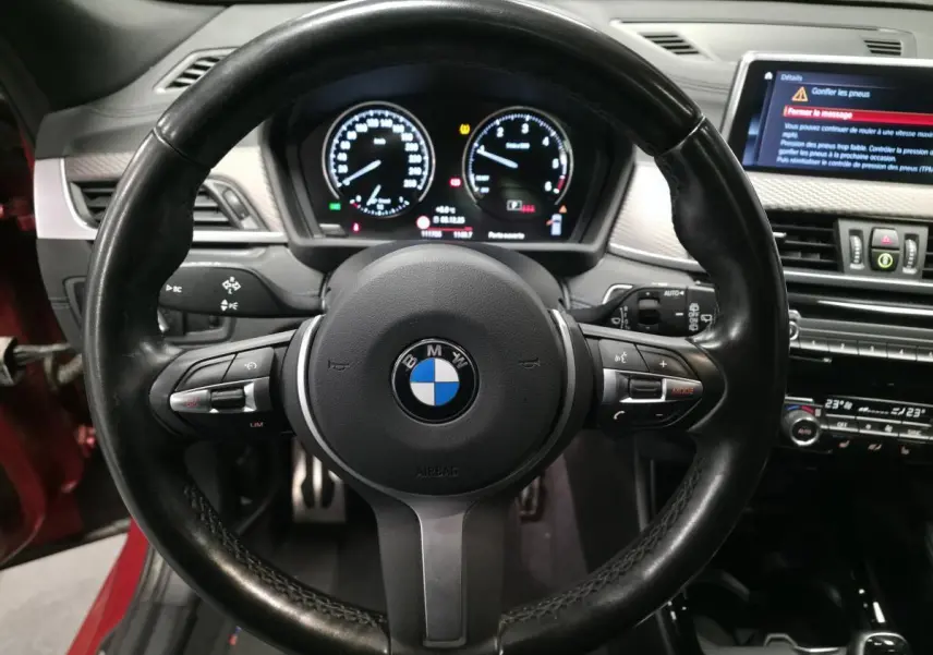 Vue rapprochée du volant M en cuir noir et du tableau de bord numérique d'une BMW X2 2021.