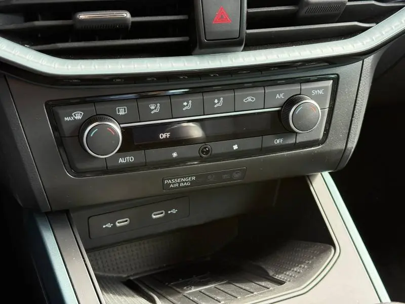 Vue rapprochée de la console centrale du SEAT Arona 2025, avec commandes climatisation et ports USB visibles.