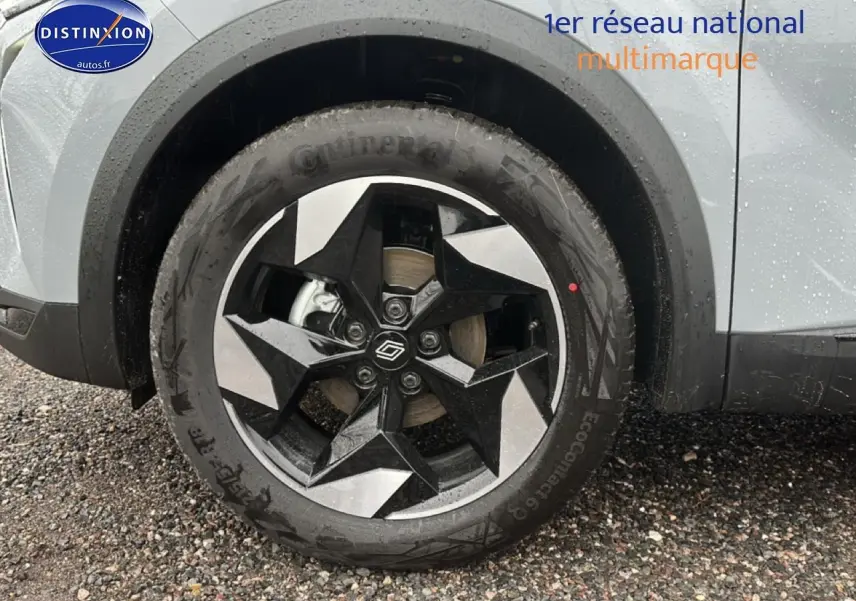 Gros plan sur la roue avant gauche du Renault Captur gris rafale avec jante alu au design géométrique noir et argent.