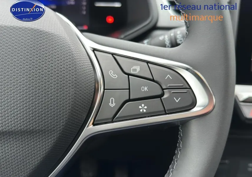 Gros plan sur les commandes multifonctions à droite du volant cuir noir du Renault Captur gris rafale 2025.