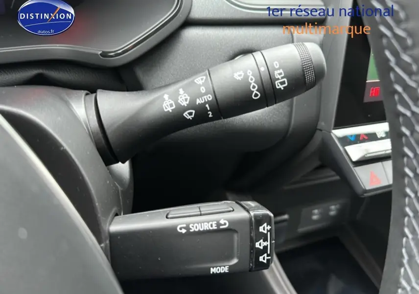 Gros plan sur les commandes au volant du Renault Captur gris rafale, montrant les leviers de clignotants et audio.