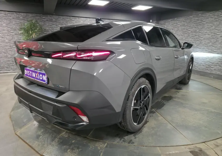 Vue 3/4 arrière droit d'une Peugeot 408 gris métallisé avec feux arrière LED en forme de griffe et jantes alliage 19 pouces.