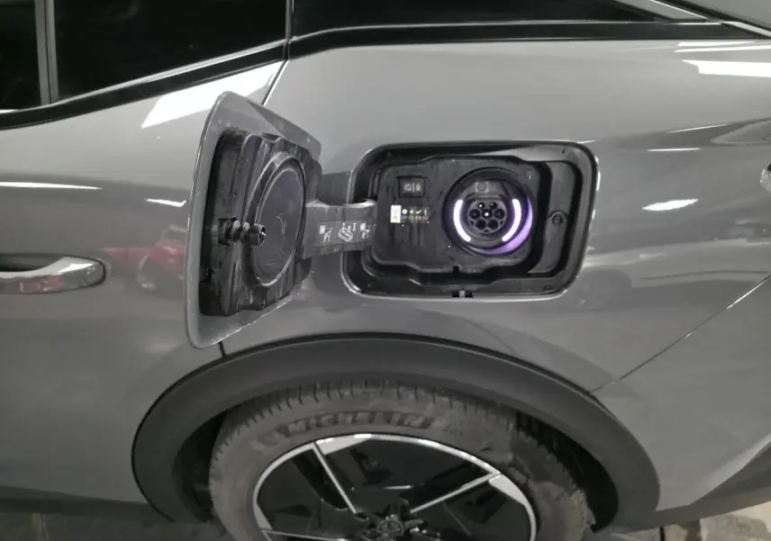 Prise de recharge ouverte côté gauche arrière sur Peugeot 408 gris métallisé avec jante alliage 19 pouces.