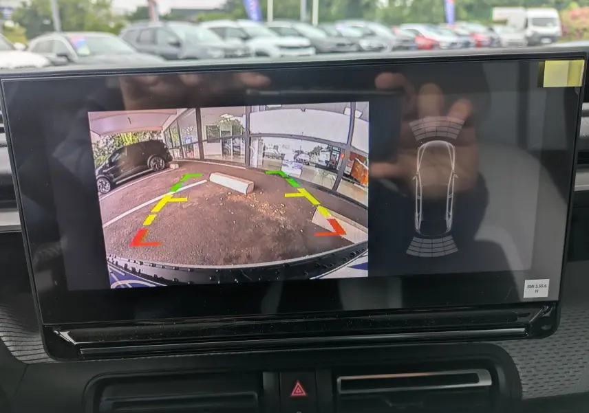Écran intérieur montrant la caméra de recul avec vue arrière du parking, sans visibilité directe du véhicule.