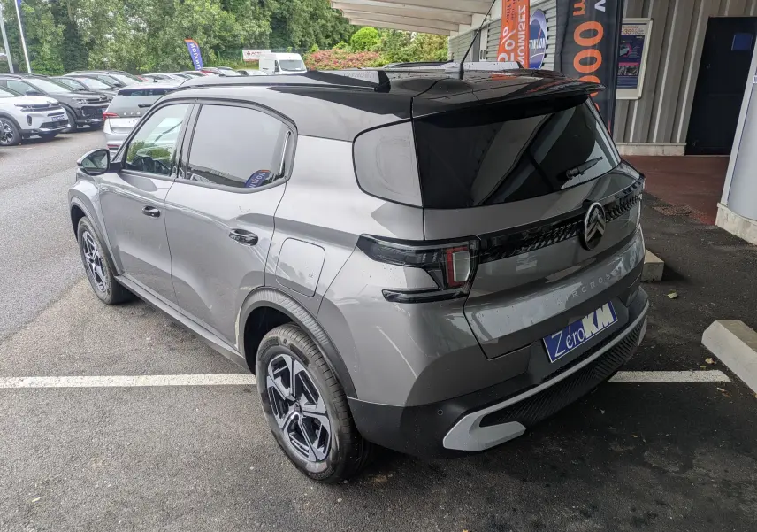 Vue 3/4 arrière droite d'une Citroën C3 Aircross 2026 gris Mercuy avec toit noir et jantes bi-ton.