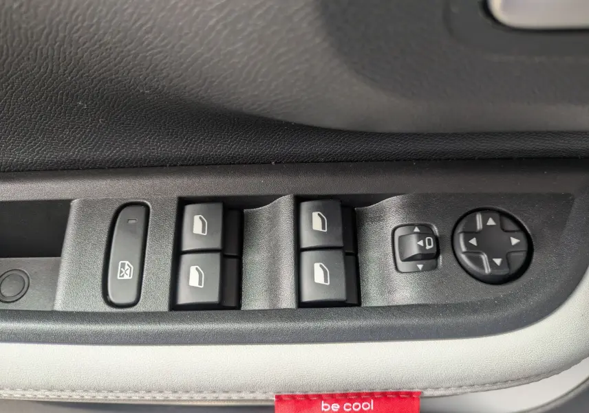 Commande des vitres et réglage des rétroviseurs sur la porte côté gauche d’un Citroën C3 Aircross gris Mercuy toit noir.