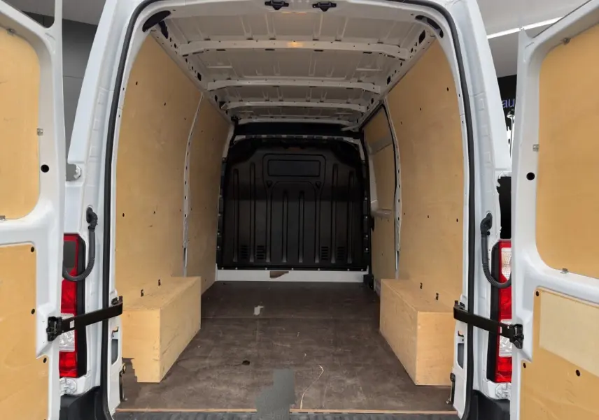 Vue arrière du Renault Master blanc 2024 avec portes ouvertes, montrant l'intérieur de chargement équipé d'un kit bois complet.