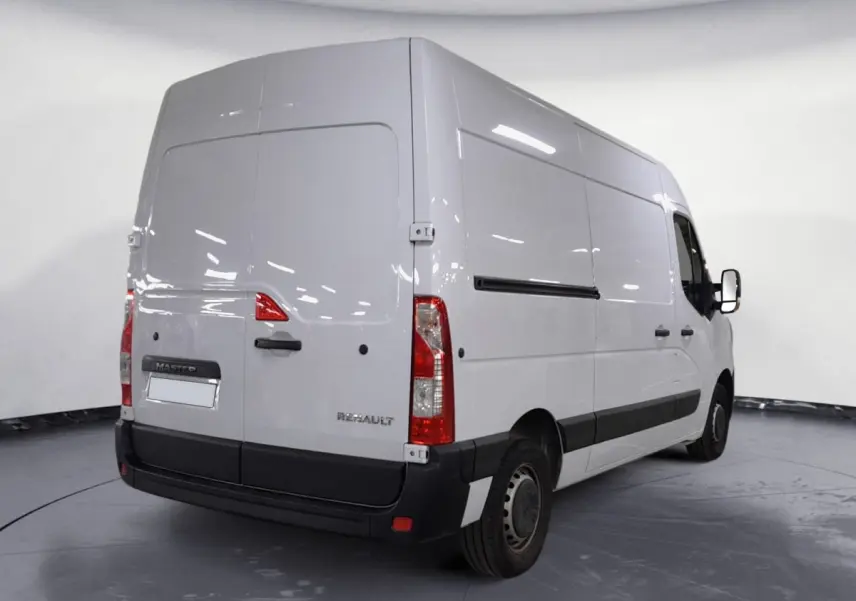 Vue 3/4 arrière droite d’un Renault Master blanc utilitaire avec portes arrière pleines et protections noires.