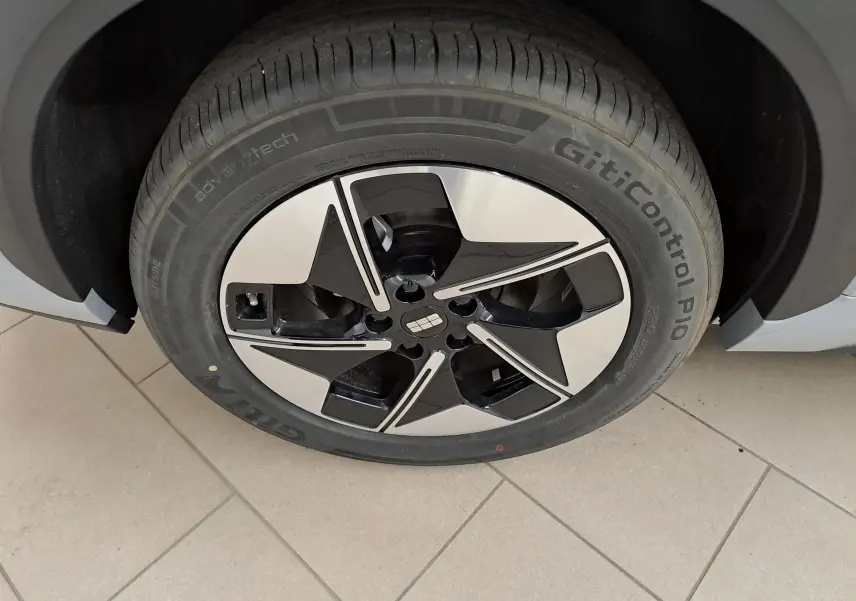 Gros plan sur la roue avant droite du Geely E5 PRO gris Moonlight, avec jante noire et argentée au design moderne.
