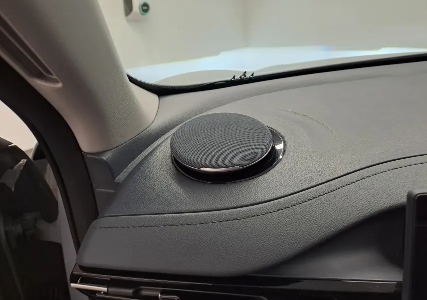 Gros plan sur le haut-parleur rond intégré au tableau de bord gris du Geely E5 PRO 218ch 60kWh 2026, côté gauche.
