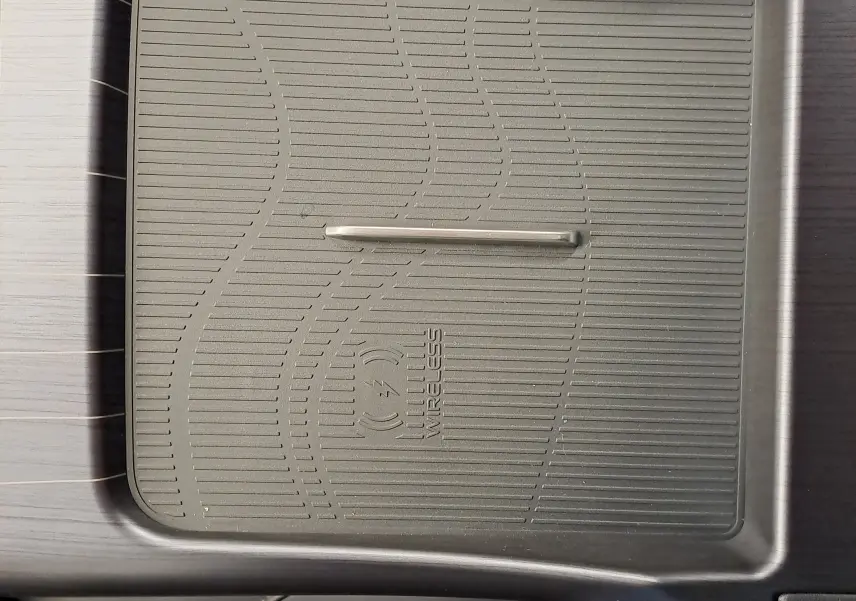 Gros plan sur le chargeur sans fil gris intégré à la console centrale du GEELY E5 PRO 218ch 60kWh 2026.