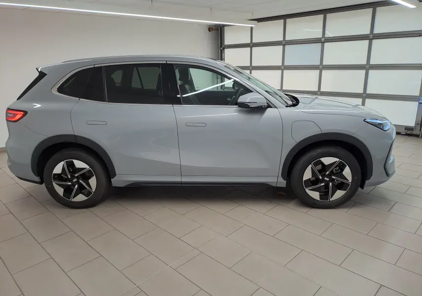 Vue de profil côté gauche du SUV électrique GEELY E5 PRO 218ch gris Moonlight avec jantes noires et grises distinctives.