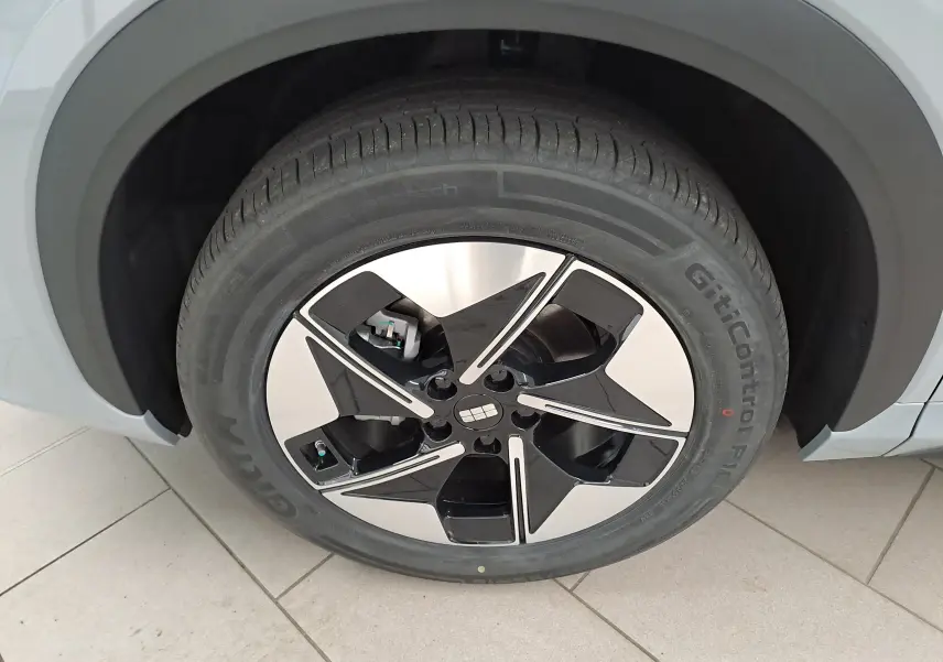 Gros plan sur la roue avant gauche du Geely E5 PRO gris Moonlight, avec jante noire et argentée au design moderne.