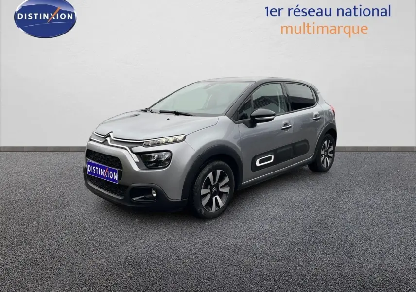 Citroën C3 gris acier métal en 3/4 avant droit, avec protections latérales noires et jantes bi-ton.