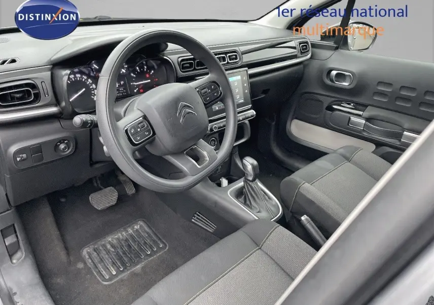 Intérieur avant droit de la Citroën C3 2023 gris acier, volant multifonction et console centrale avec écran tactile visible.
