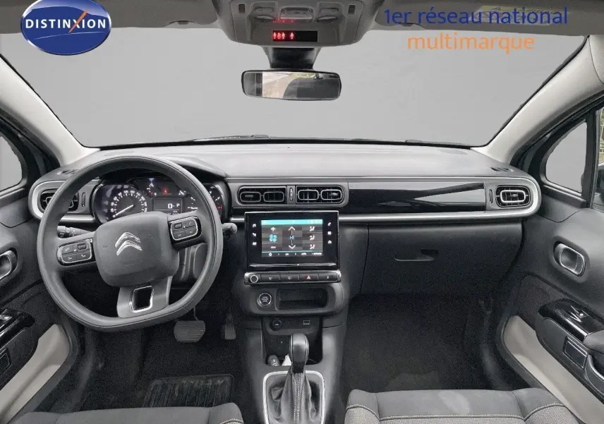 Intérieur de la Citroën C3 2023 gris acier, vue frontale du tableau de bord avec écran tactile et volant multifonction.