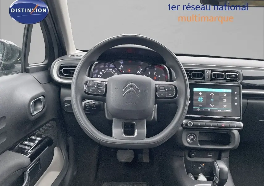 Vue frontale de l'intérieur de la Citroën C3 2023 gris acier, avec tableau de bord numérique et écran tactile central.