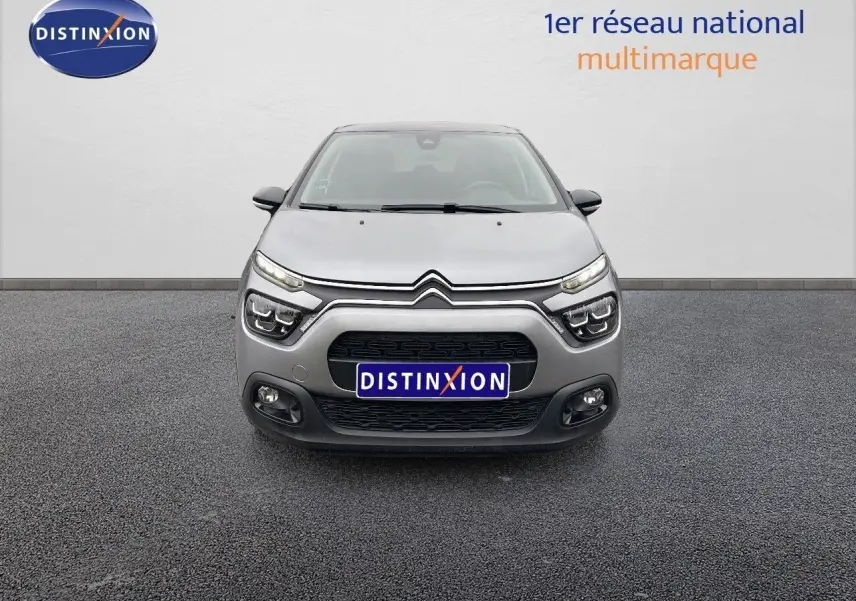 Vue frontale d'une Citroën C3 2023 gris acier métal avec ses phares LED et calandre noire distinctive.