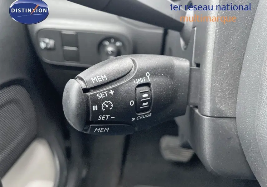 Gros plan sur la commande de régulateur de vitesse noire dans l'habitacle d'une Citroën C3 gris acier 2023