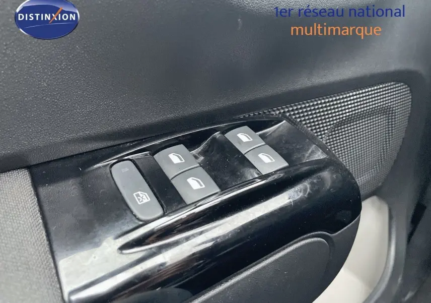 Gros plan sur les commandes des vitres électriques côté conducteur d'une Citroën C3 gris acier métal 2023.