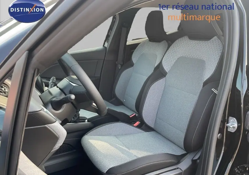 Vue intérieure côté conducteur de la Renault Clio 2025 noir étoile métal, sièges tissu gris clair et noir avec coutures blanches.