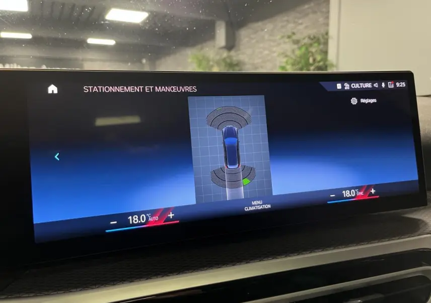 Écran central du BMW Série 3 G21 320e Touring affichant l'aide au stationnement avec vue du véhicule en bleu.