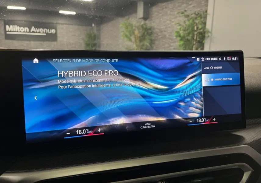 Écran BMW Live Cockpit affichant le mode de conduite Hybrid Eco Pro dans une Série 3 Touring 320e noire, vue intérieure frontale.