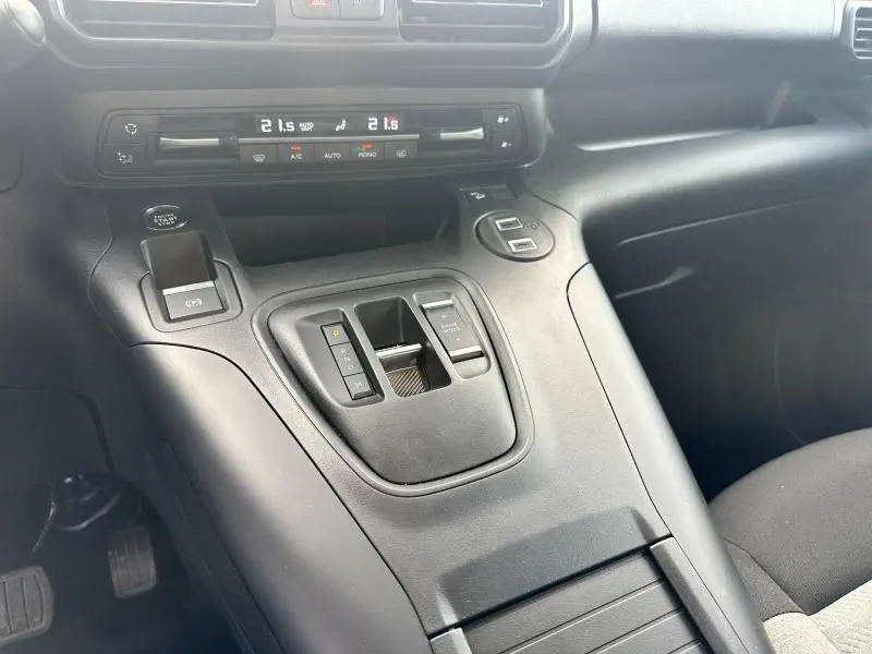 Console centrale noire du Citroën Berlingo XL 2024 avec commandes de boîte automatique et climatisation bi-zone visible