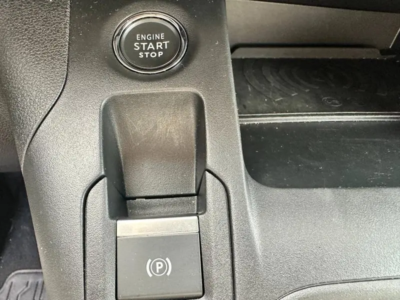 Gros plan sur la console centrale noire du Citroën Berlingo 2024 avec bouton Start/Stop et frein à main électrique.