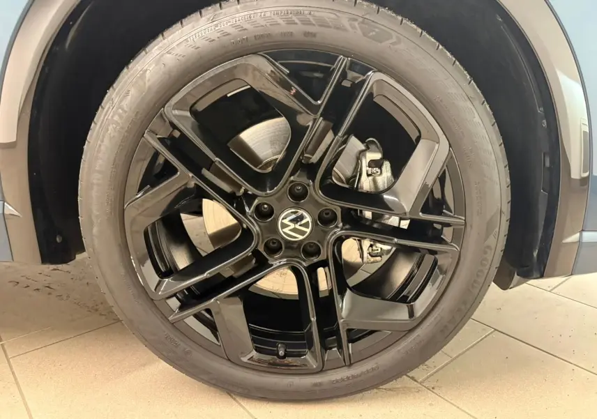 Gros plan sur la jante noire 20 pouces York du Volkswagen Tiguan Nightshade Blue, avec pneu Goodyear visible.