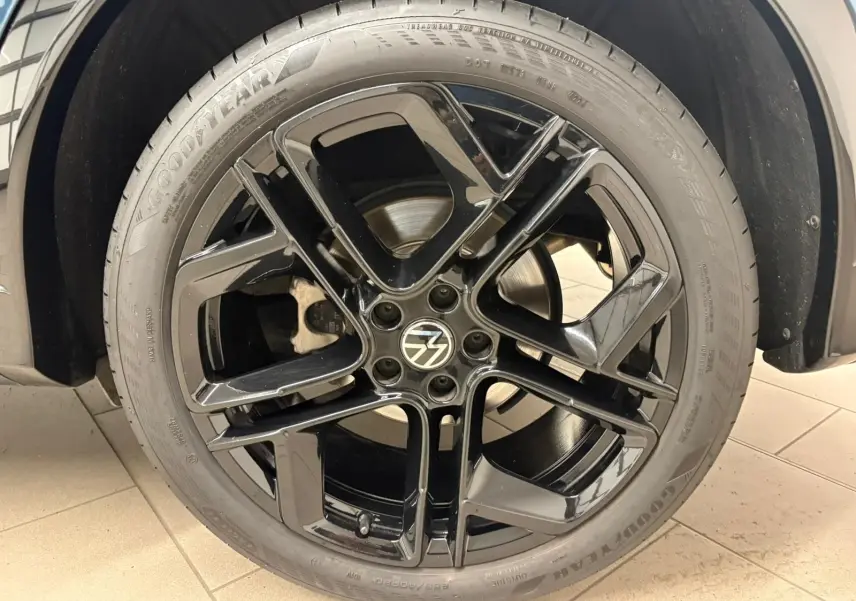 Gros plan sur la jante noire 20'' York en alliage du Volkswagen Tiguan Nightshade Blue, avec pneu Goodyear.