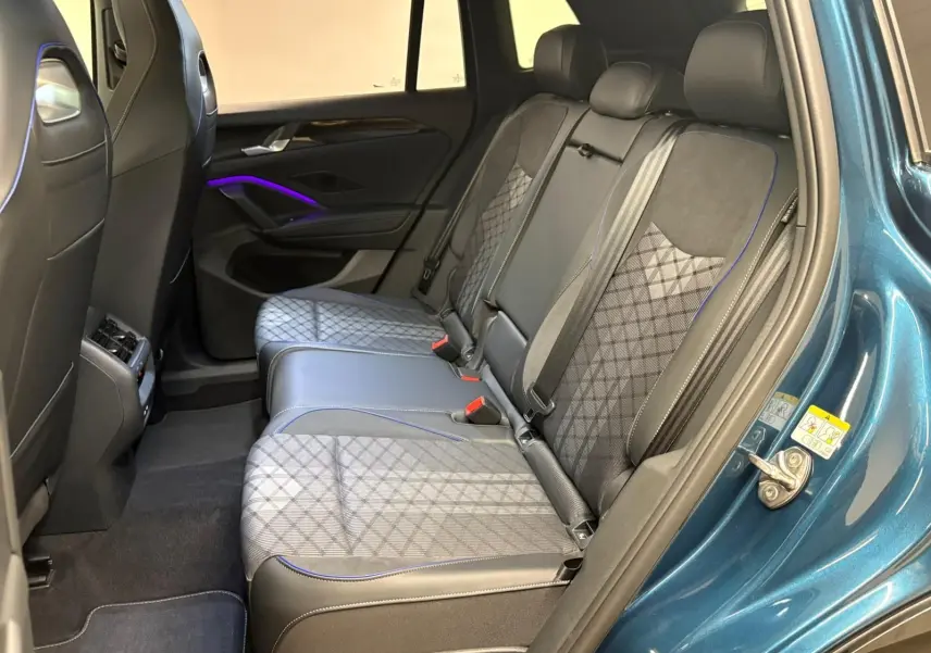 Vue intérieure arrière côté droit du Volkswagen Tiguan 2024 Nightshade Blue avec sièges en tissu et cuir noir à surpiqûres bleues.