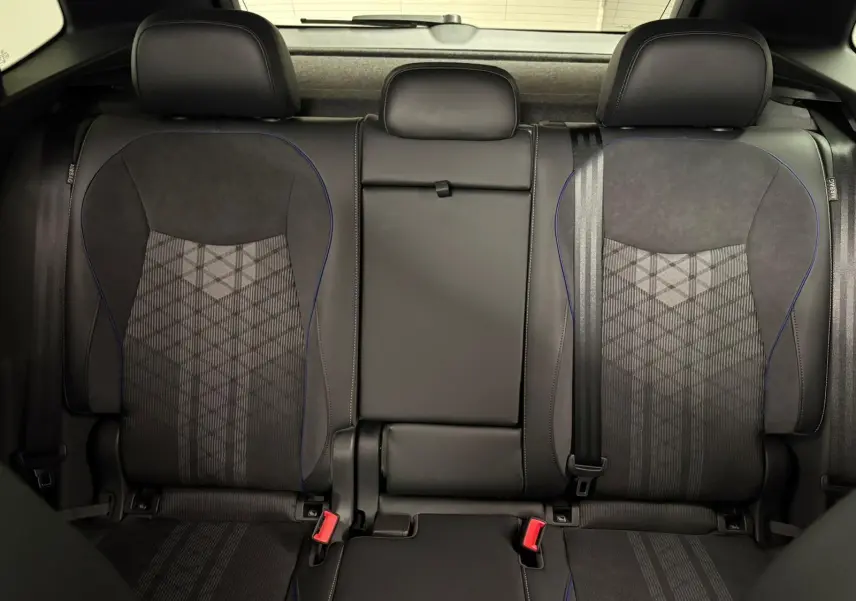 Vue intérieure des sièges arrière noirs avec surpiqûres bleues du Volkswagen Tiguan 2024, finition R-Line.