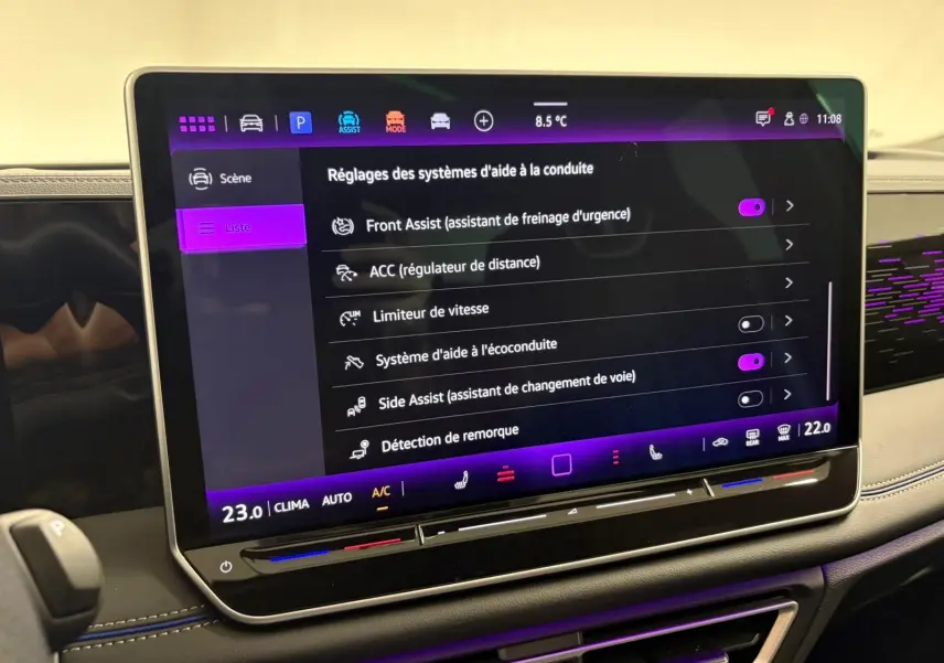 Écran tactile central du Volkswagen Tiguan 2024 affichant les réglages des aides à la conduite, intérieur noir avec surpiqûres bleues.