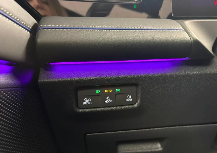 Gros plan sur la commande d’éclairage avec ambiance lumineuse violette dans l’habitacle du Volkswagen Tiguan 2024.