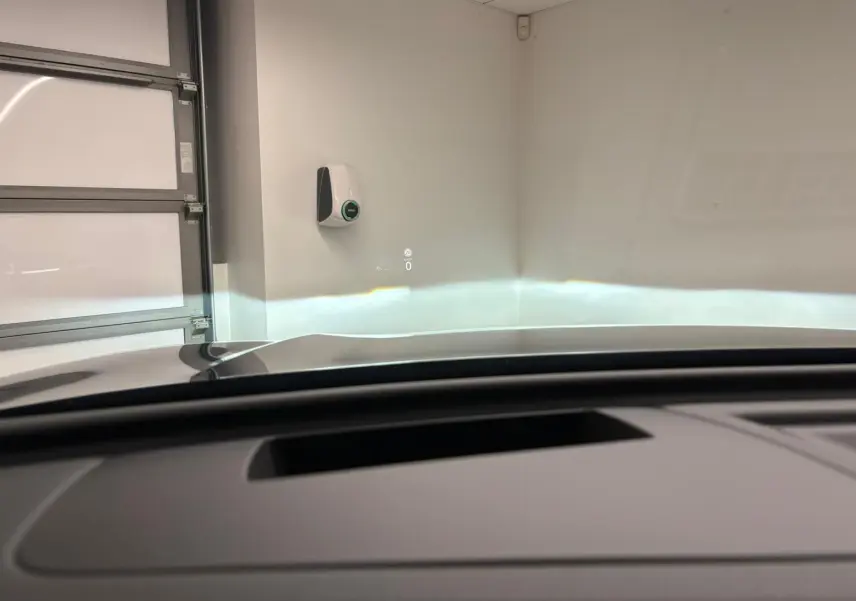 Vue intérieure du Volkswagen Tiguan 2024 avec affichage tête haute projeté sur pare-brise, toit ouvrant partiellement visible.