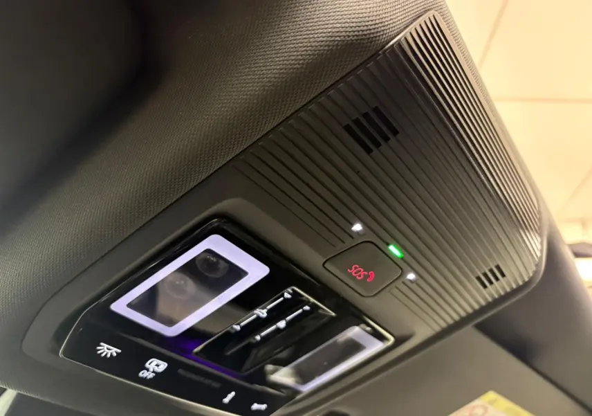 Vue rapprochée du panneau de commande du toit ouvrant panoramique avec bouton SOS et éclairage intérieur du Volkswagen Tiguan 2024.