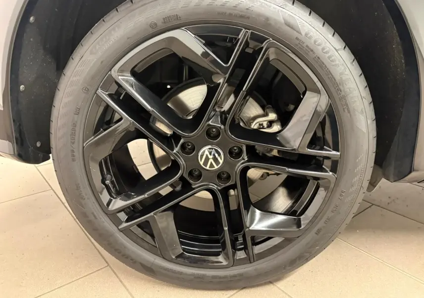Gros plan sur la jante noire 20 pouces York du Volkswagen Tiguan Nightshade Blue, avec pneu Goodyear visible.