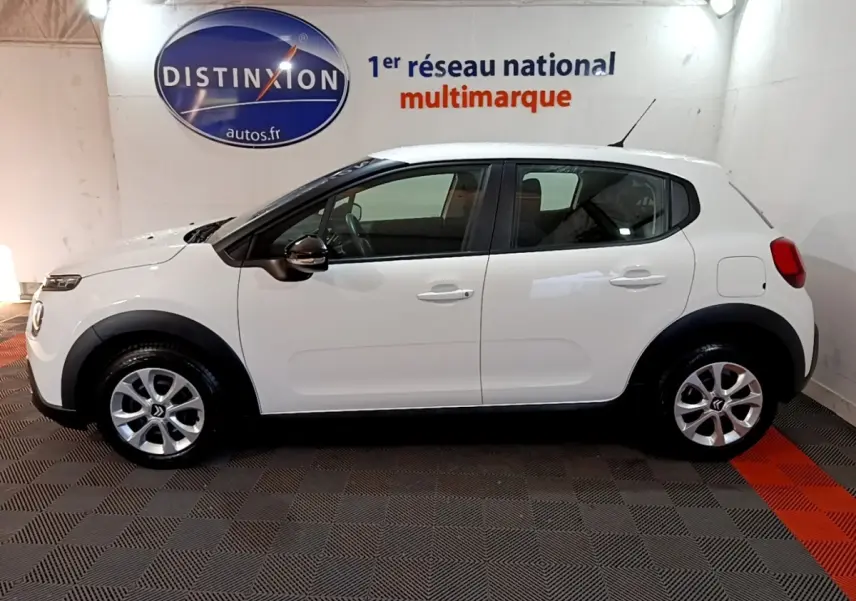 Vue de profil côté gauche d'une Citroën C3 blanche PureTech 82 S&S BVM Feel Business, avec jantes argentées et rétroviseurs noirs.